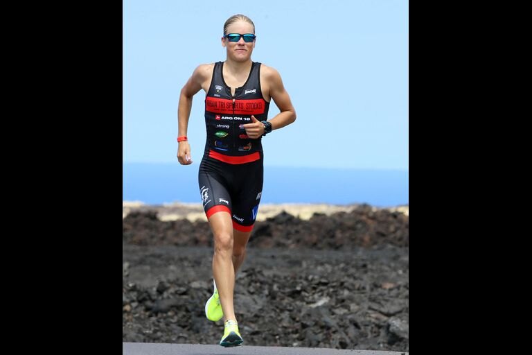 Alexandra Tondeur en course à pied sur un champ de lave, en trifonction noire et rouge aux couleurs de la Belgique.