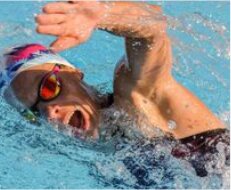 Alexandra Tondeur en natation, en pleine reprise de nage, bonnet et lunettes.