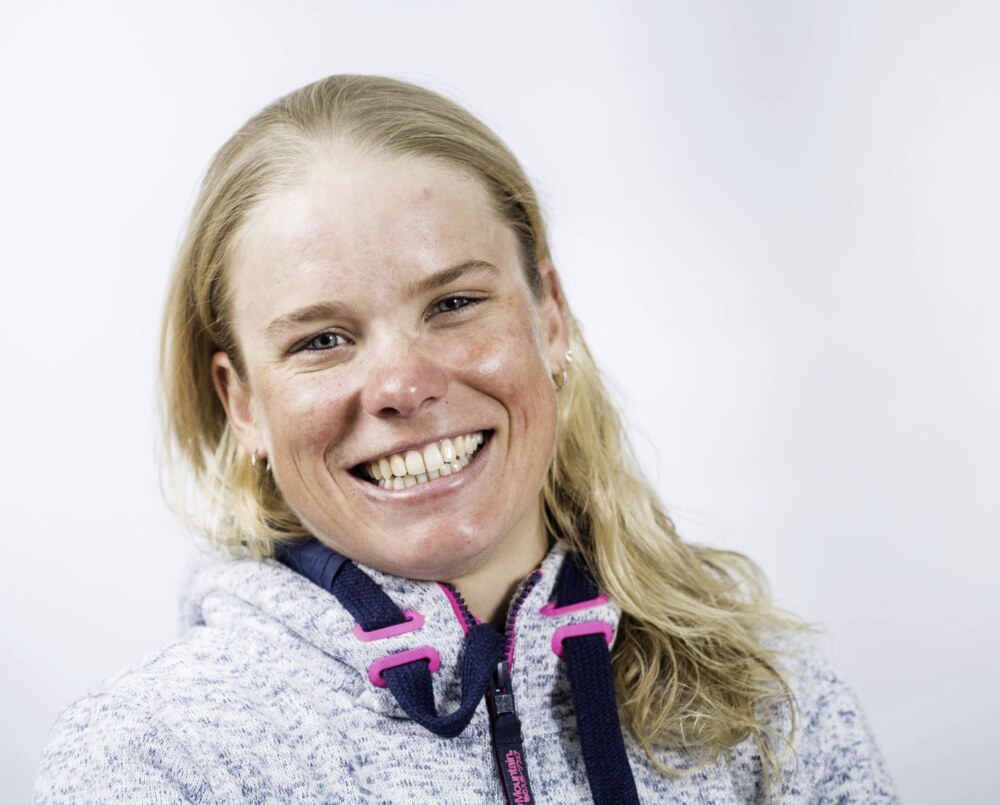 Portrait rapproché d'Alexandra Tondeur, souriante, sur fond clair.