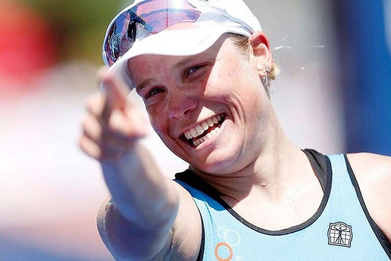 Alexandra Tondeur, souriante et casquette sur la tête, pointe le doigt vers l'objectif après une arrivée.